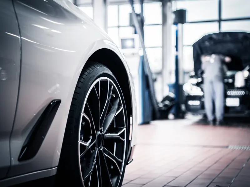 Car in garage with mechanic in background