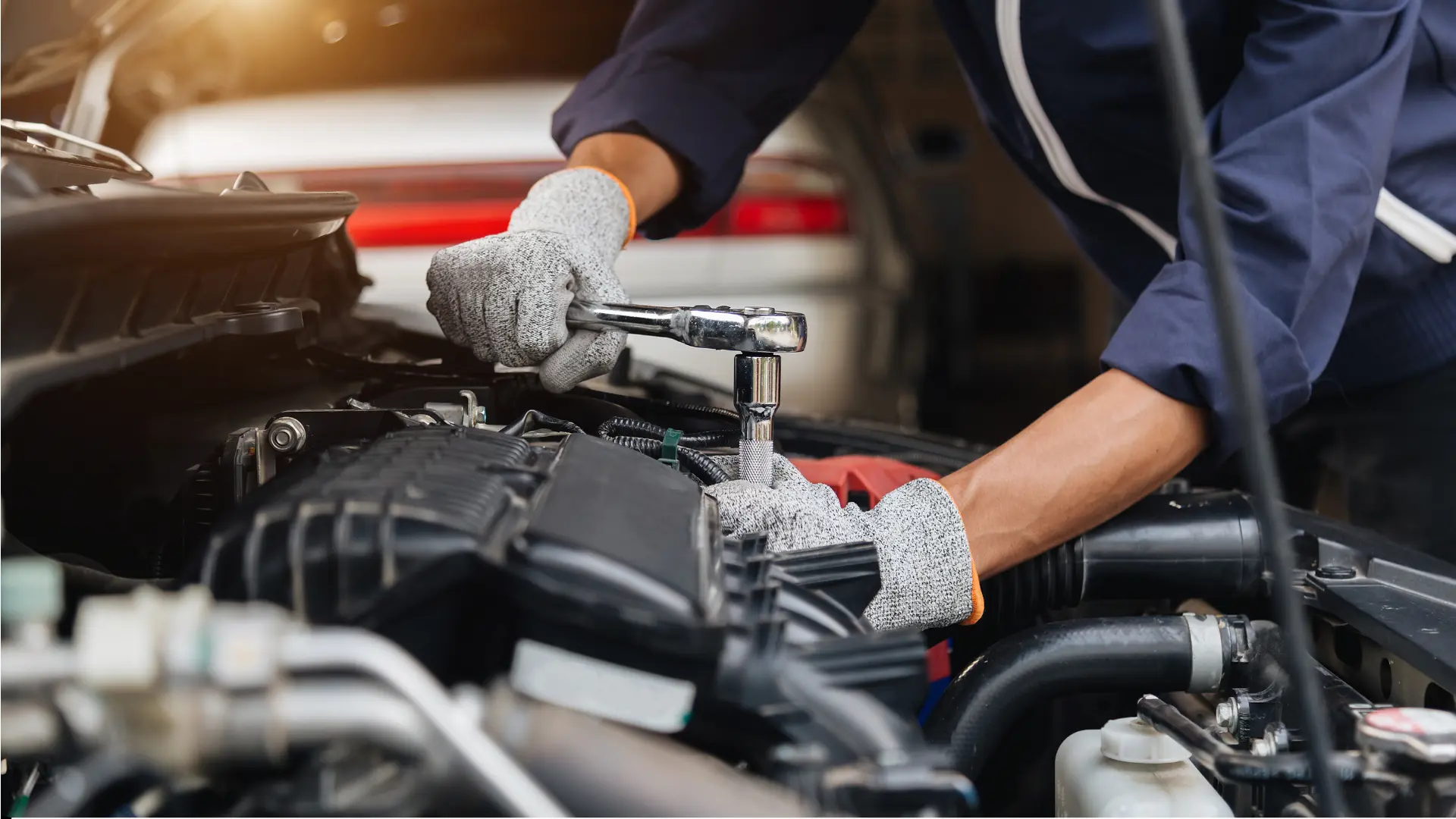 Mechanic using wrench on car engine.