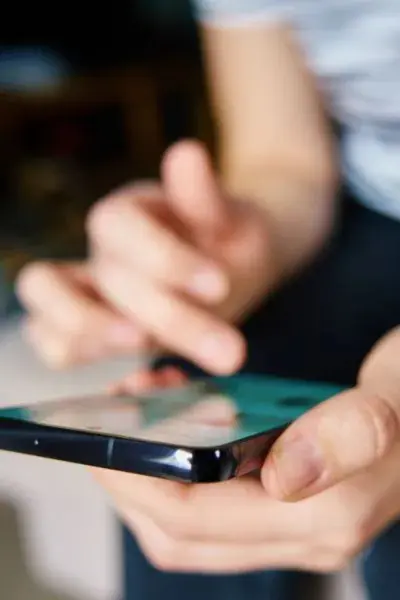 Person using smartphone touchscreen.