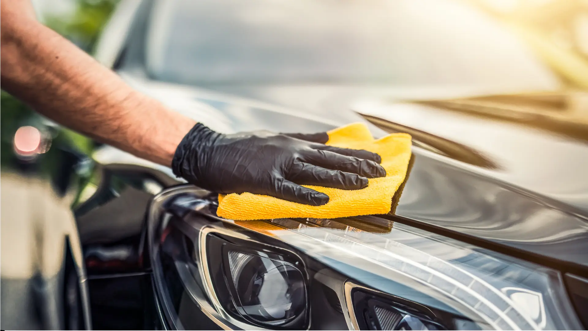 Hand cleaning car headlight with cloth