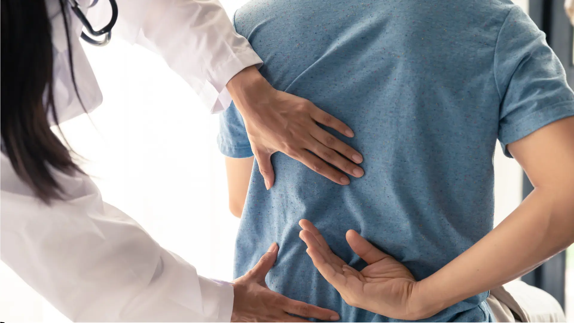 Doctor examining patient's back pain.