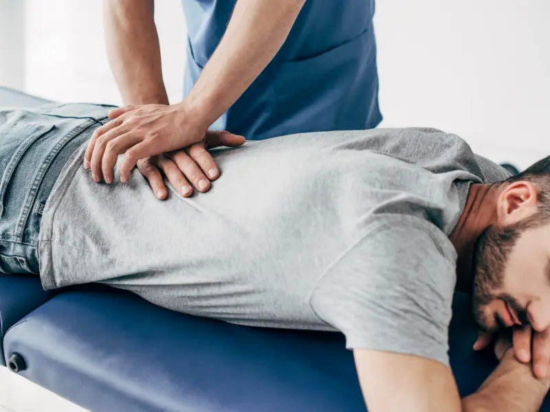 chiropractor internet marketing Chiropractor adjusting patient's back on table.