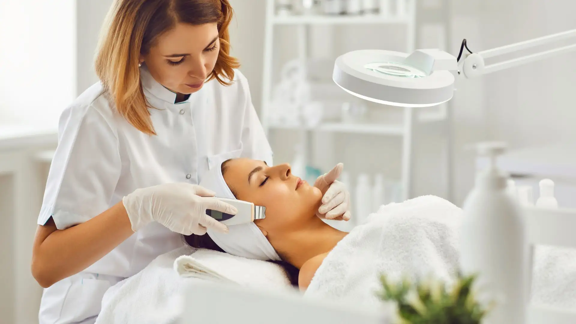 Esthetician performing facial treatment on client.