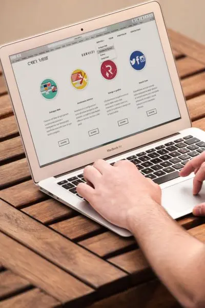 Person using laptop with website on screen.