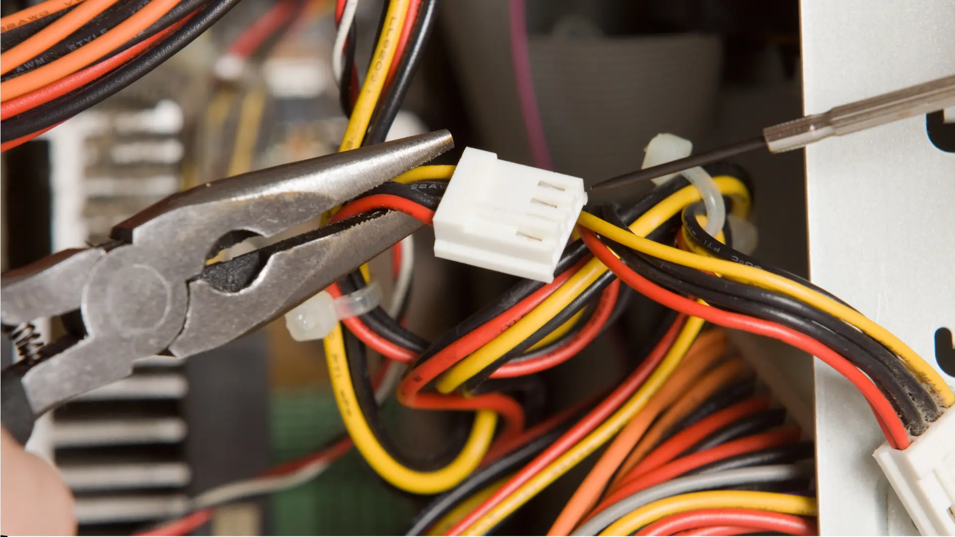 Pliers and cables in computer maintenance scene.