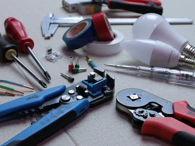 Assorted electrical tools and supplies on table.
