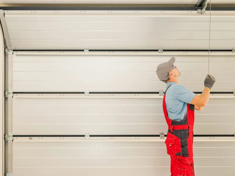 garage door company internet marketing Technician inspecting garage door system.