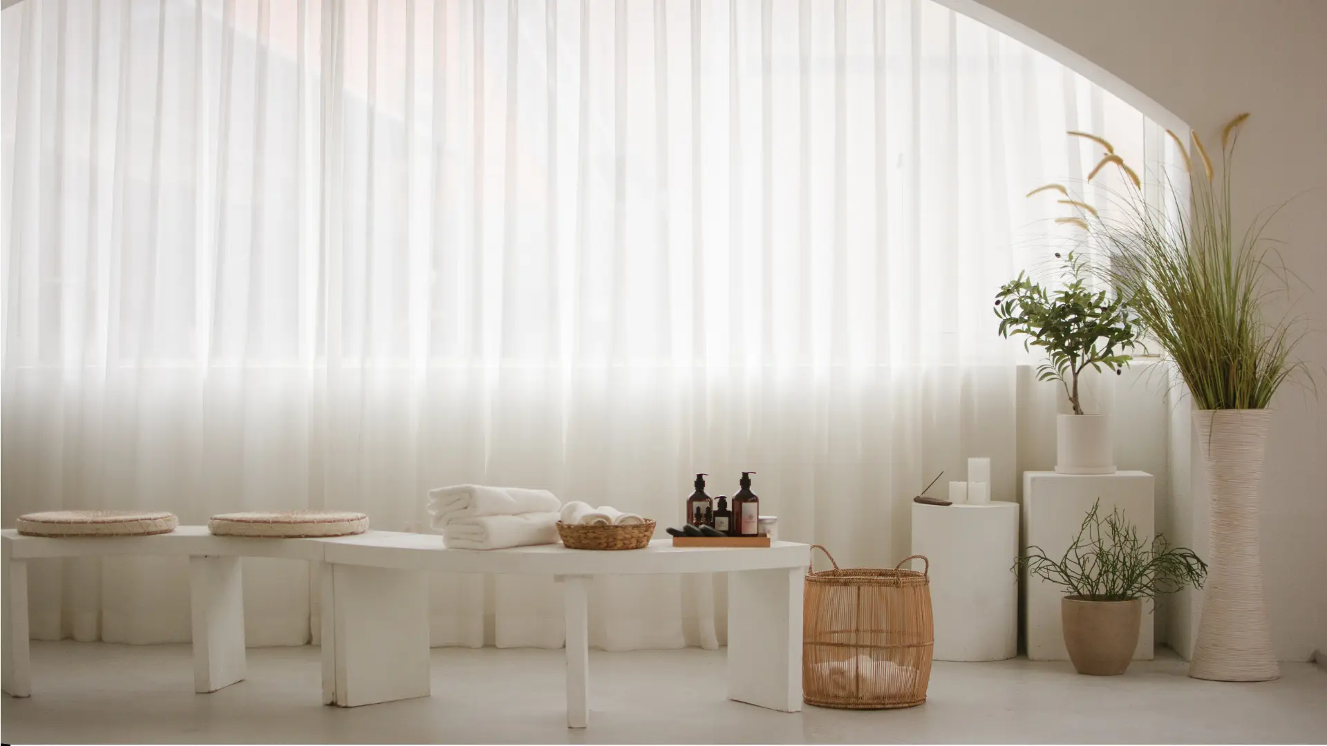 Minimalist spa decor with plants and towels.