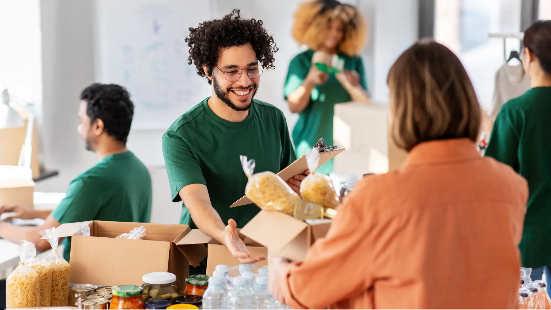 Volunteers organizing donated food items at charity.
