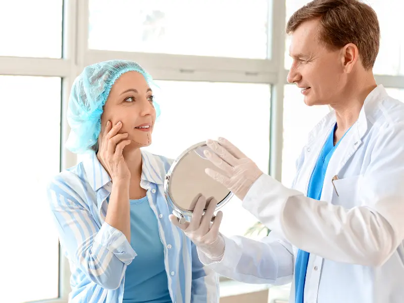 plastic surgeon internet marketing Doctor showing patient results with mirror in clinic.