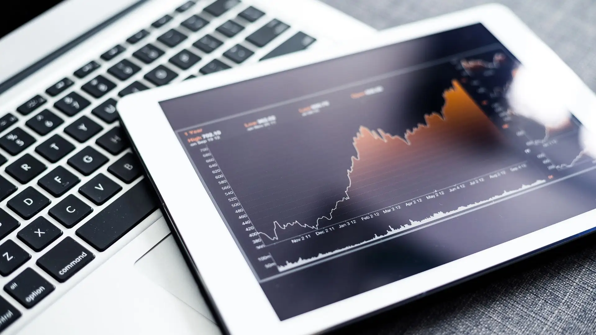 Tablet displaying financial stock graph on laptop